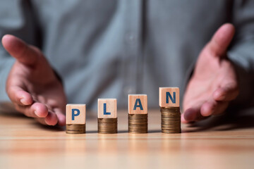 Investment and saving concept,  businessman 's hand with word GOAL on money coin stacking. deposit and money plan concept.