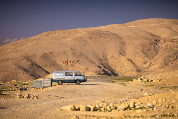  Z Madaby nad Morze Martwe w Jordanii. Samochód na pustynnej drodze z widokiem na góry.