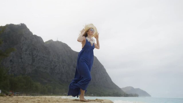 RED camera panorama shot around travel lady with lei flower neckless standing in scenic nature of Oahu 4K. 30s authentic traveler woman in purple maxi boho style dress enjoying view of Hawaiian beach