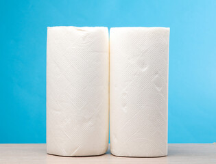 Rolls of white paper towels on the table, blue background