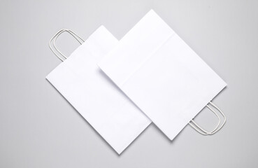 Two paper white shopping bags on gray background. Template for design. Creative mockup