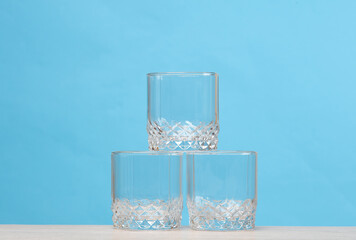 Three empty glasses on the table, blue background
