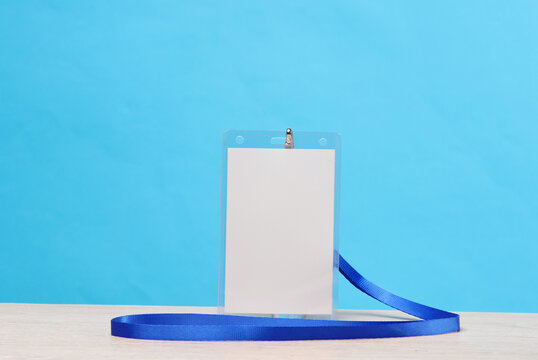 White blank Id identification card on a belt, blue background. Template for design