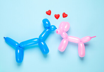 Two love balloon dogs kiss with hearts on a blue background