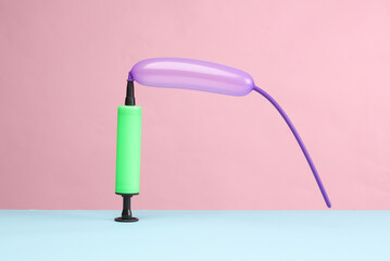 Balloon with pump on blue pink background. birthday, party fun