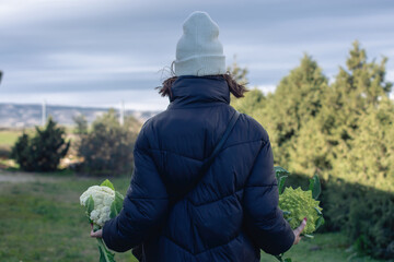 Attractive woman carrying freshly picked vegetables from the orchard