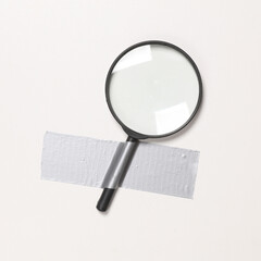magnifying glass fixed with adhesive tape on white background. Conceptual pop, contemporary art,...
