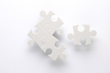 White jigsaw puzzle pieces on white background.