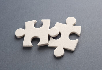 Fototapeta premium White jigsaw puzzle pieces on dark background.