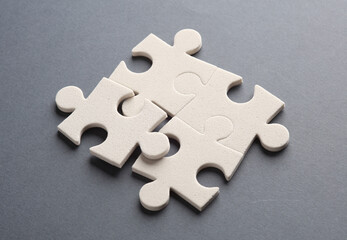 White jigsaw puzzle pieces on dark background.