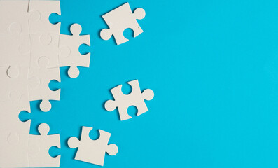 White jigsaw puzzle pieces on blue background.