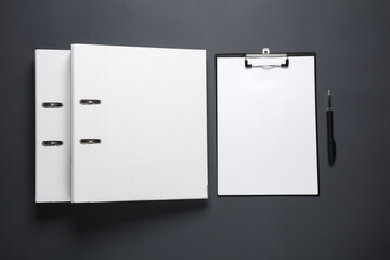 White binder folder and clipboard, pen on a dark background. Business concept