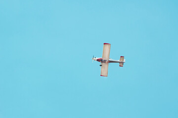 light aircraft transporter of water, against the background of the blue sky, flies to extinguish a...