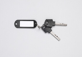 Plastic tag with keys on gray background