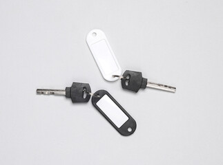 Plastic tags with keys on gray background