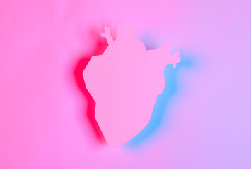 Paper cut anatomical heart silhouette in red blue neon light