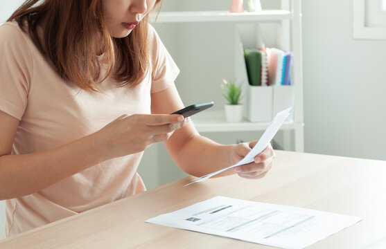 Modern woman use phone to scan barcode or QR codes to pay credit card bill after receive document invoice. payment, receive, paying electricity, digital payments without money, technology, scanning