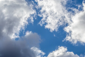 Clear cloudy sky on sunny winter day. Cumulus, blue window in cloudy sky. Bottom-up view. Cloudy sky on sunny winter day