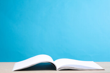 Open magazine on the table, blue background