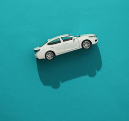 Toy car model against blue background. Top view. Minimalism