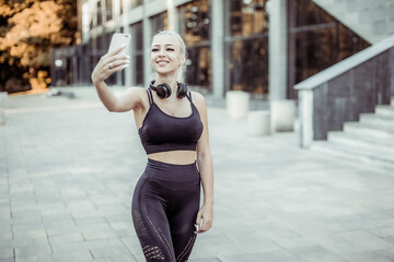 Young fitness girl taking selfie on the phone outdoors