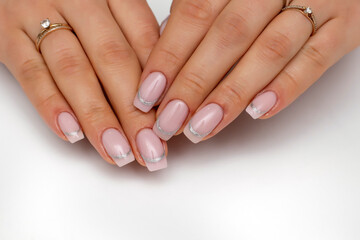 Light pink manicure on long square nails with a silver stripe. Oval stripe. French.