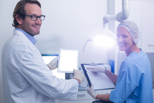 Portrait of dentist and dental assistant working on digital tablet - Powered by Adobe