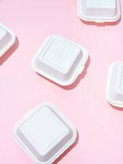 Ecological food delivery packaging. Burger takeaway boxes on green and pink background