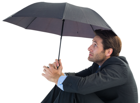 Businessman holding umbrella sitting on the floor