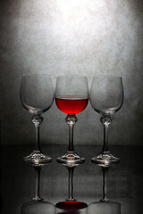 Still life with three glasses of red liquid
