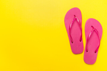 Bright flip flops on color background, top view