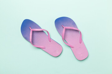 Bright flip flops on color background, top view