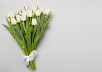 White tulip bouquet on color background, top view