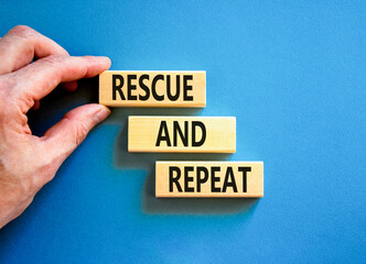 Rescue and repeat symbol. Concept words Rescue and repeat on wooden block on a beautiful blue table...
