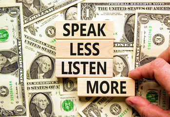 Speak less listen more symbol. Concept words Speak less listen more on wooden block. Beautiful background from dollar bills. Motivational business speak less listen more concept. Copy space.