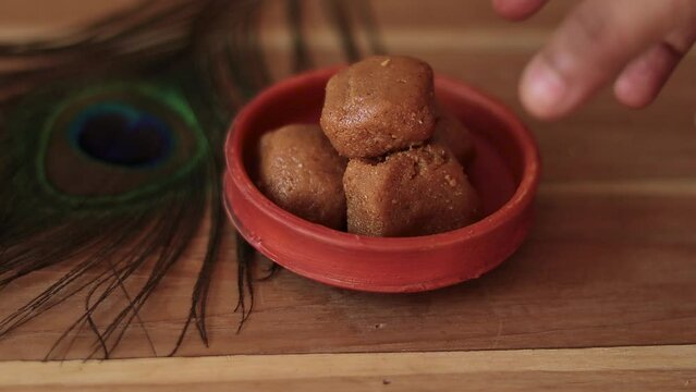 Mathura ka peda is served on a clay plate with peacock feather during celebration of Krishna janmashtami. This traditional Indian sweet originated in mathura is made of khoya or Mawa, ghee and sugar.