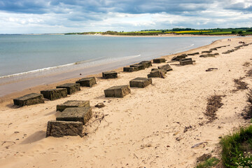 Partially buried concrete World War two anti-tank barricades remain in place over seventy five...