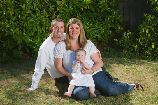 Portrait of a young couple with a baby on the grass; Moraga california united states of america