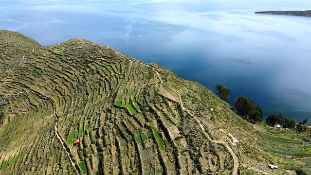 Aerial shot drone flies west over highest point of Isla del Sol in Lake Titicaca