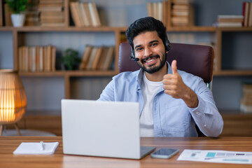 Handsome hispanic man working using computer happy with big smile doing ok sign, thumb up with fingers, excellent sign