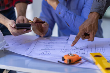 Engineer pointing at blueprint and using laptop to draw project design building construction architect Contractor and foreman meeting with floor plan for real estate development project industry