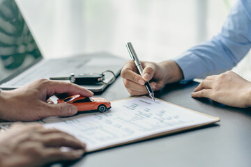 Naklejka premium Salesman guiding customer seated at table. Car business. Car sale. Dealership closing. and the new owner has entered into a contract The idea of ​​selling and renting a car with insurance.