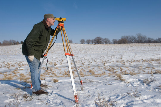 Man surveys farmland in winter near Dunbar in Nebraska, USA; Nebraska, United States of America