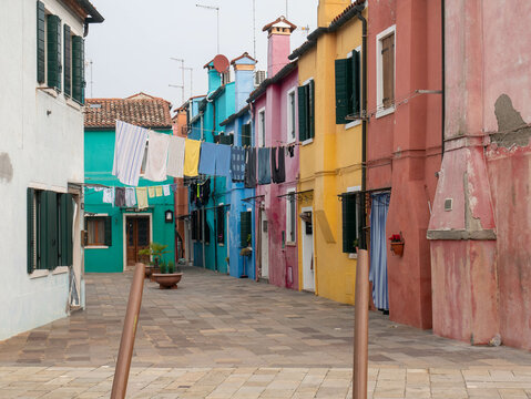 La ropa colgada en un tendedero para secarse entre las famosas casas de colores brillantes de Burano, Italia, ofrece una visi&oacute;n de la encantadora vida cotidiana de la isla veneciana.