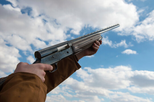 Close-up of a person aiming a rifle at the sky; Bennet, Nebraska, United States of America