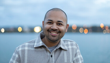 Outdoor portrait of a young man along the water; New Westminster, British Columbia, Canada