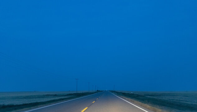 Highway through the Alberta prairies at blue hour; Alberta, Canada