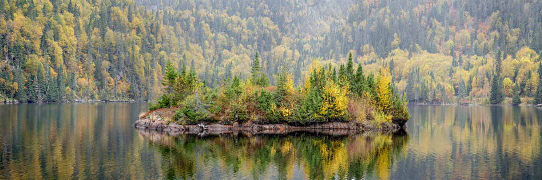 Picturesque autumn coloured landscape with a small island in a lake; Terrace Bay, Ontario, Canada