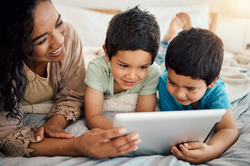 Tablet, education and a mother with her children on a bed at home in the morning together for entertainment. Family, boy or brother with a woman and her kids learning online in the bedroom of a house