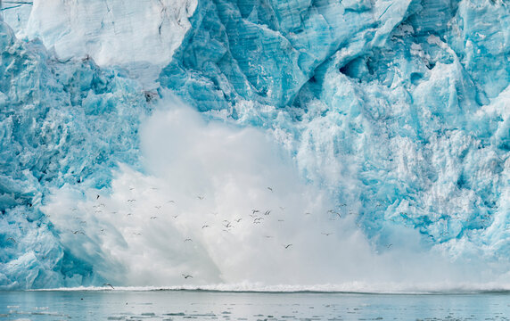 Water spray explodes after ice from the Monacobreen Glacier crashes into the sea; Norway
